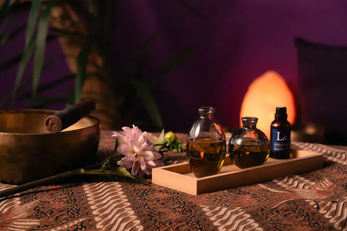 Huiles de massage, bol tibétain et lampe de sel dans le cabinet de massage Koram à Yverdon-les-Bains. Accessoires de détente et soins naturels sur une table de massage